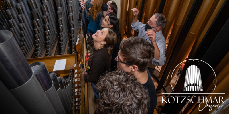 Group standing and listening to organ