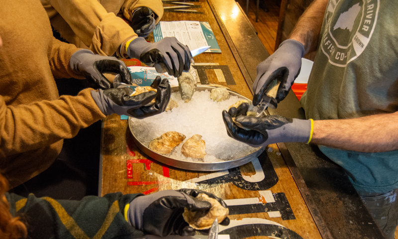 Shucking Oysters at Maine Oyster Co. Photo Credit: Lauren Witt at Visit Portland