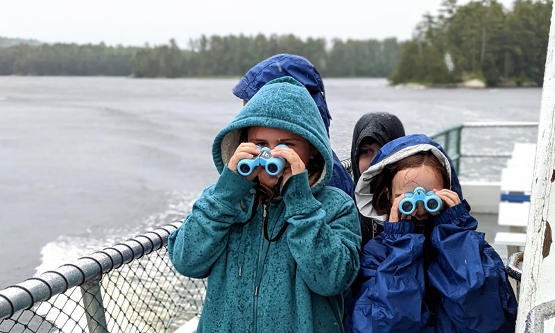 Kids enjoying binoculars on rainy day: Photo Credit: Maine Maritime Museum